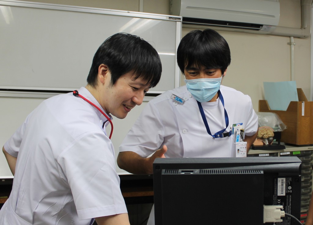 ▲電子カルテで画像所見を確認 （左：宮田五月脳神経外科副部長　右：江原幸康研修医）